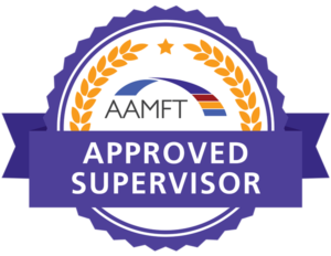 Badge with the text AAMFT Approved Supervisor in the center. The badge features a blue arch with red, white, and blue stripes, surrounded by a golden laurel wreath, all on a purple background.